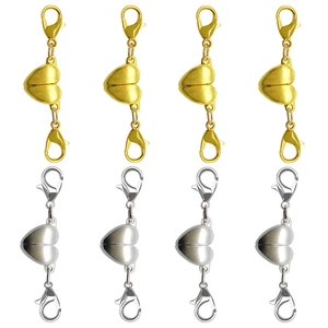 Macro detail of heart-shaped magnetic jewelry clasps with double lobster claws in gold and silver