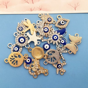 Dettaglio di ciondoli Occhio di Allah e Mano di Fatima con smalto blu e strass