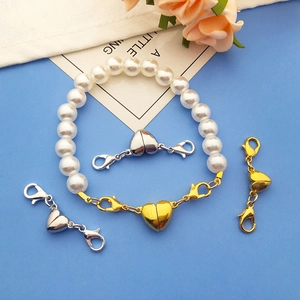Detail of heart-shaped magnetic jewelry clasps with lobster hooks on a pearl bracelet