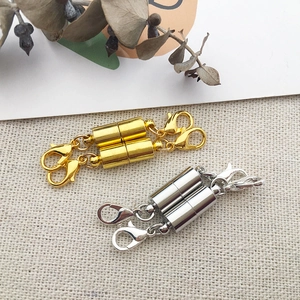 Gold and silver magnetic jewelry clasps with lobster buckles on a textured fabric