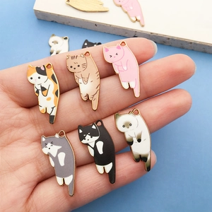 Bunte Emaille-Katzenanhänger für DIY-Schmuck in der Hand gehalten als Bastelzubehör