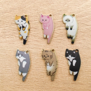 Set mit sechs bunten Katzen-Emaille-Anhängern für DIY-Schmuck auf Holzoberfläche