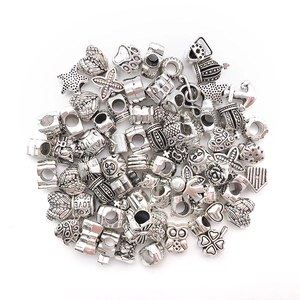 Macro shot of silver alloy DIY charm beads featuring vintage hearts stars and owls