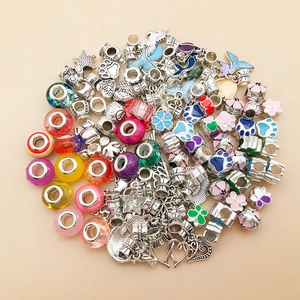 Detailed close-up of mixed colorful glass beads and silver enamel charms for DIY bracelets