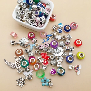 Detailed flat lay of colorful enamel alloy charms and glass beads for DIY bracelet making