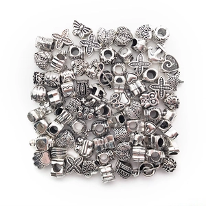 Detailed view of assorted silver vintage DIY charm beads with heart and animal motifs