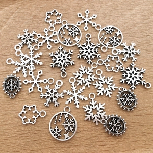 Detailansicht verschiedener Schneeflocken-Anhänger und Himmelsmotive für DIY-Schmuck
