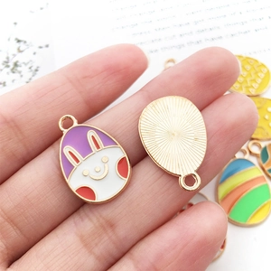 Detail view showing front enamel rabbit pattern and back textured gold metal of Easter egg pendant