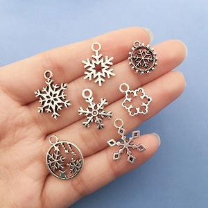 Set aus 7 silbernen Schneeflocken-Anhängern für DIY-Weihnachtsschmuck auf blauem Hintergrund