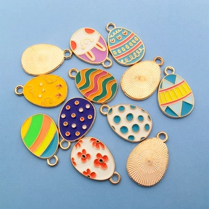 Macro shot of colorful Easter egg alloy charms with rabbit and floral motifs for DIY jewelry
