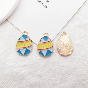 Macro view of geometric enamel easter egg charms with golden radial texture on back