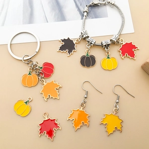 Detail of Thanksgiving jewelry set with pumpkin and maple leaf enamel charms for DIY