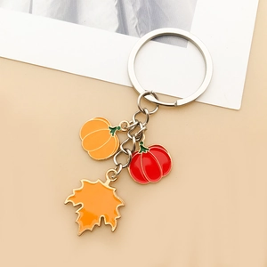 Detail of DIY pumpkin and maple leaf charms with gold trim for Thanksgiving jewelry