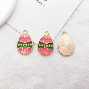 Detail of three Easter egg charms with pink and green enamel petals and gold plating