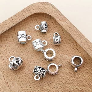 Macro shot of vintage silver alloy charms and beads with intricate engraved patterns