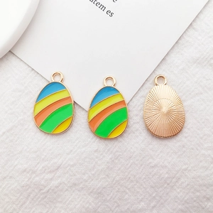 Macro view of colorful Easter egg charms with vibrant stripes and radial metal texture