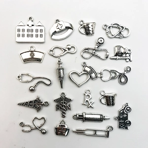 Détail de breloques médicales en argent antique avec stéthoscope et bonnet d'infirmière