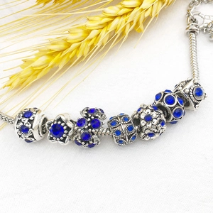 Detailed close-up of Pandora style snake chain bracelet with blue crystals and silver beads