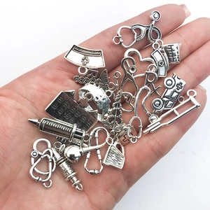 Vue détaillée des breloques médicales en argent vintage avec stéthoscope et seringue