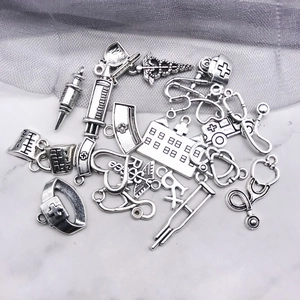 Détails de pendentifs médicaux vintage en argent incluant stéthoscope et chapeau d'infirmière