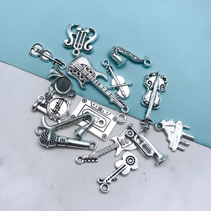Detail of silver musical instrument charms including violin and guitar for DIY crafts