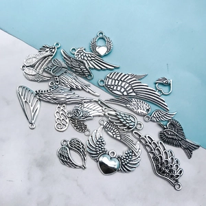 Macro shot of assorted silver alloy dragonfly wings and vintage feather charms for jewelry DIY
