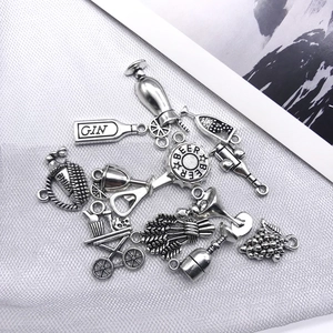 Detailed macro view of antique silver charms featuring gin bottle and wine barrel designs
