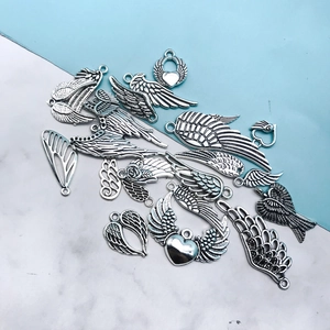 Detailed macro view of vintage silver alloy heart wing charms for DIY jewelry making