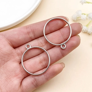 Close-up of circular open frame charms for DIY resin jewelry held in hand