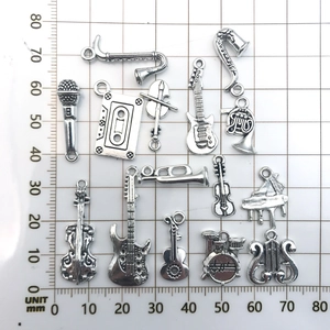 Set of 14 silver musical instrument charms for DIY jewelry making on a grid scale