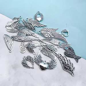 Detailed close-up of various vintage silver wing pendants for DIY jewelry making