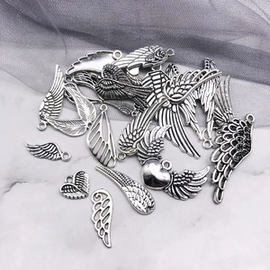Macro detail of antique silver wing charms with intricate relief textures for DIY jewelry