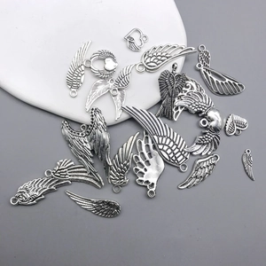 Detailed close-up of antique silver heart wing charms with intricate feather textures