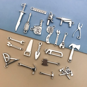 Macro detail of antique silver DIY alloy hardware tool pendants including wrench and hammer