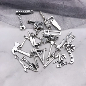 Detailed macro view of 20 miniature zinc alloy tool pendants for DIY crafts