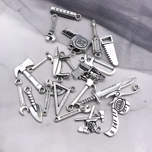 Detailed macro of antique silver alloy tool pendants for DIY jewelry and crafts