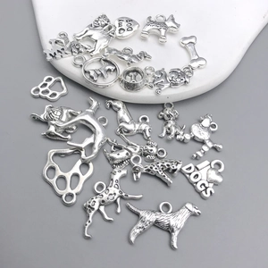 Makroaufnahme von antiken silbernen Hundepfoten und Knochenanhängern für DIY Schmuck