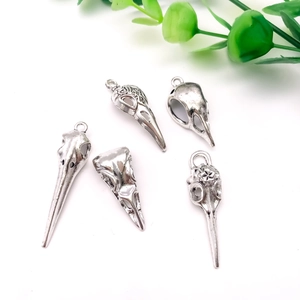 Detail of five gothic vintage silver crow skull pendants with diverse floral engravings