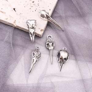 Detail of five vintage silver gothic bird skull pendants with intricate floral engravings