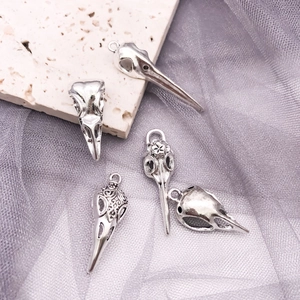 Detailed view of five gothic bird skull pendants with ornate floral relief carvings