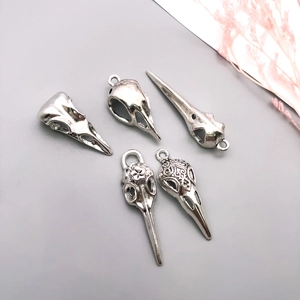 Detailed view of assorted silver gothic bird skull pendants with ornate engravings