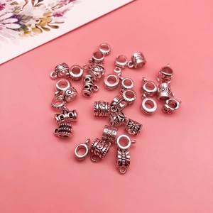 Macro detail of silver alloy spacer beads with floral and spiral textured engravings