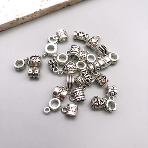 Detailed macro shot of vintage silver-style heart and flower charms for DIY jewelry making