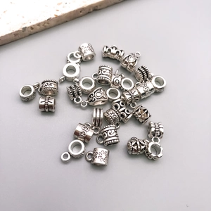 Detailed close-up of antique silver alloy heart and floral charms for DIY jewelry making