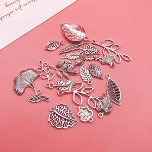 Detailed macro of silver alloy leaf charms with hollow veins for DIY jewelry making