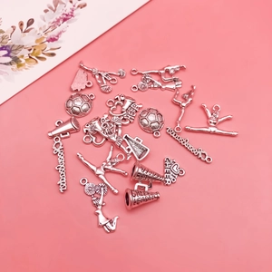Macro detail of silver cheerleader charms with football and megaphone on pink background