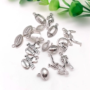 Detailed view of silver football pendants and helmet charms for DIY jewelry making