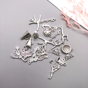 Macro detail of vintage silver cheerleader charms with cheerleader silhouettes and megaphones