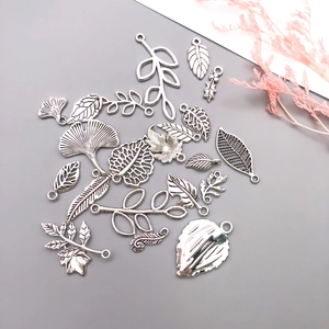 Detailed view of assorted antique silver leaf charms and pendants for DIY jewelry making