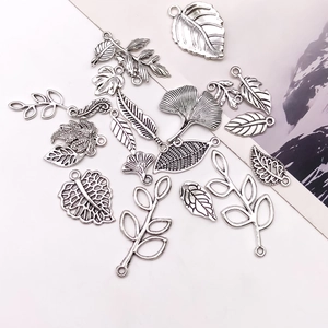 Detailed macro view of antique silver leaf pendants with intricate vein patterns for DIY jewelry